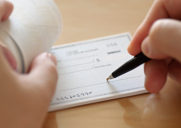person writing out a bank check